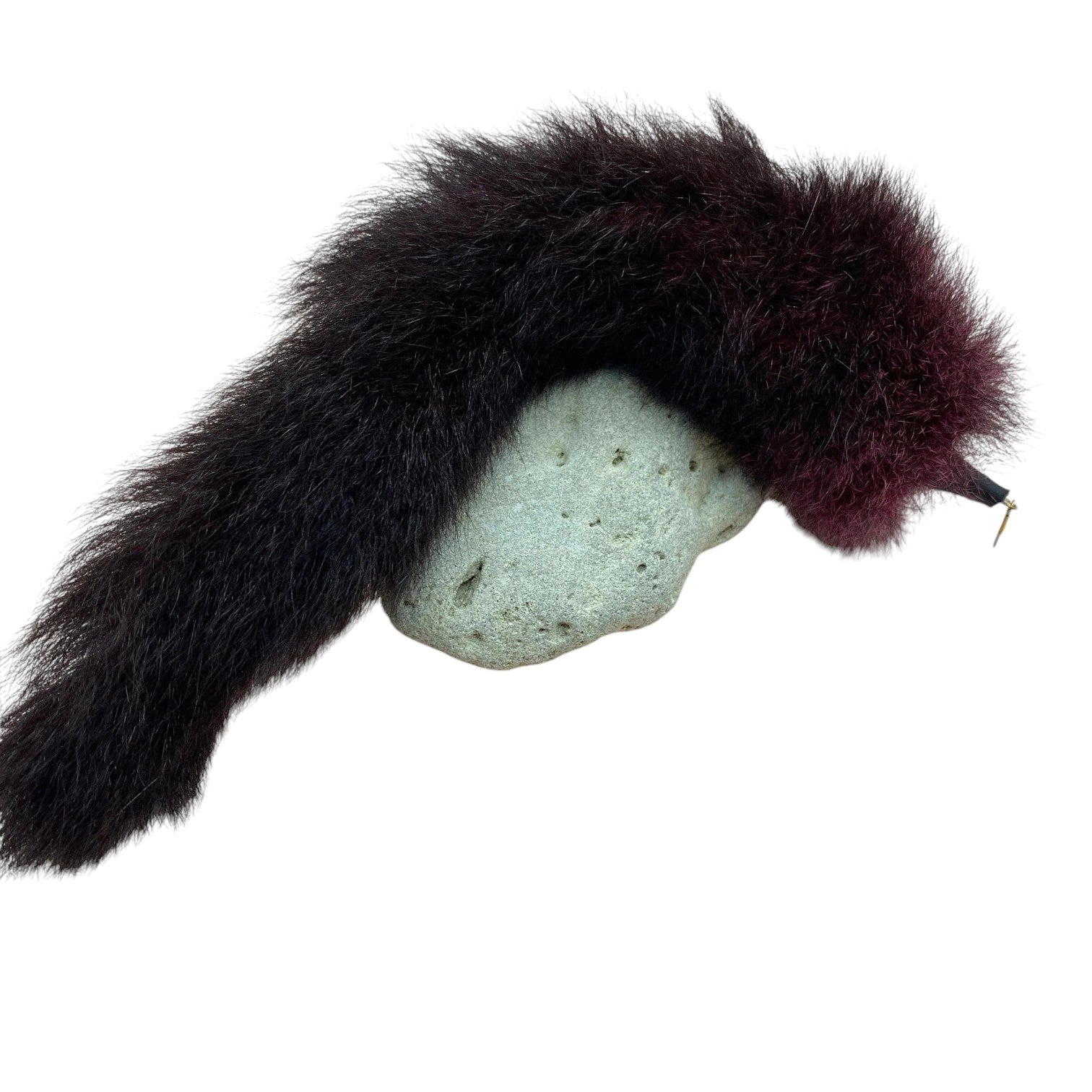 A dark brown fur toy with a light gray stone accent and a small gold pin, displayed on a white background.